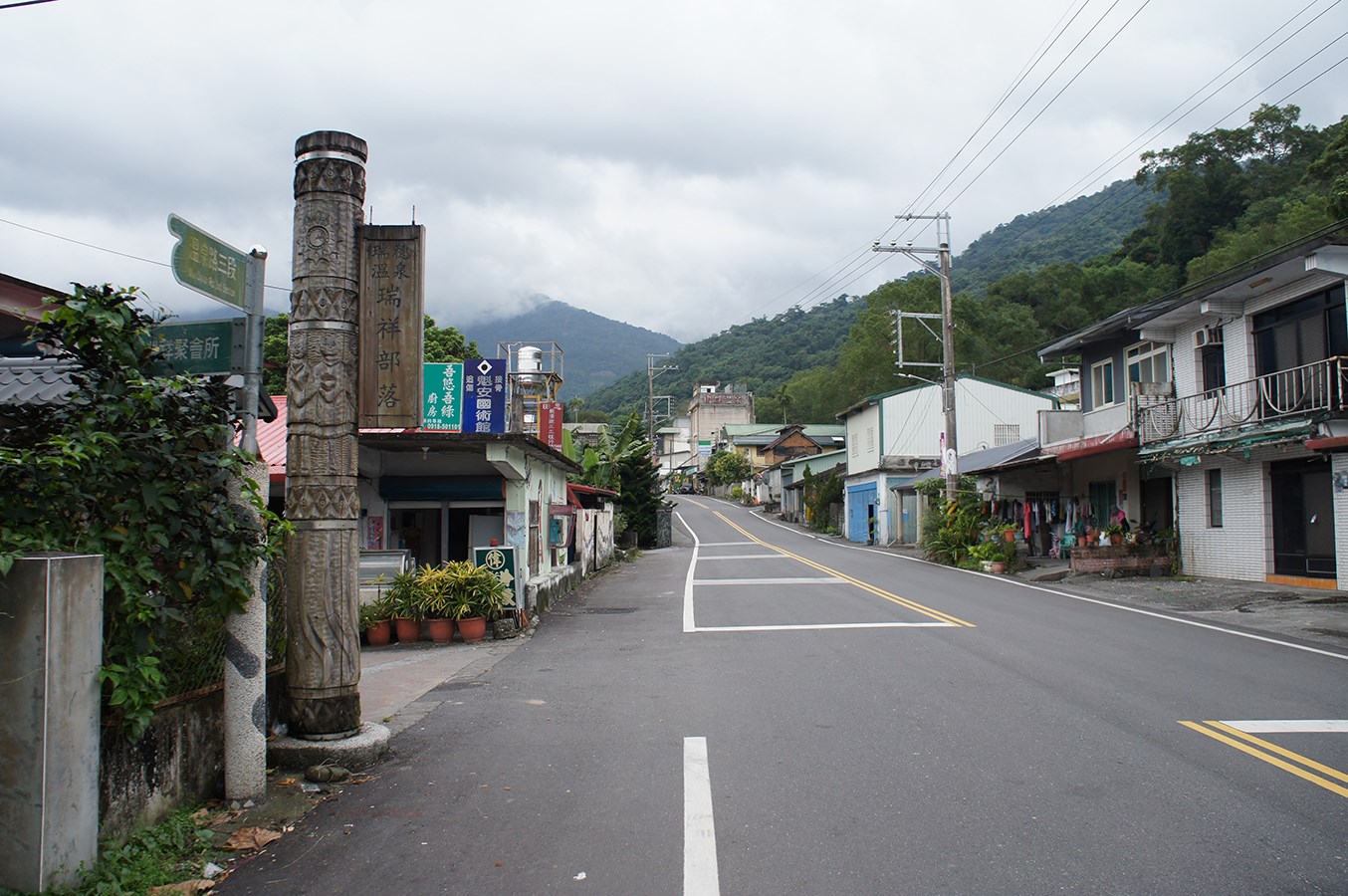 瑞祥溫泉部落入口,木柱題有溫泉瑞祥部落,旁為住宅與街道