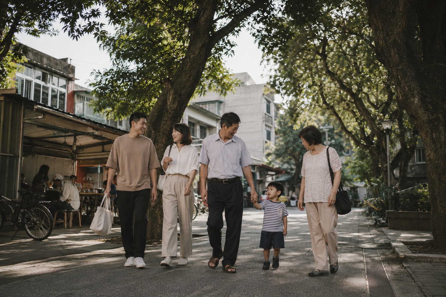 父親節午後，台灣三代家人走在住家附近安靜的街道與小公園，中年父親牽著年幼孫子的手，成年子女走在身旁自然交談，街邊有老樹、早餐店、傳統住宅與停放整齊的腳踏車，陽光穿過樹葉形成柔和光影，畫面像家人隨手記錄的一段日常