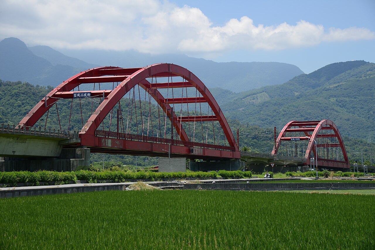 2016年拍攝的源城客城鐵橋與稻田,紅色橋身後方可見山景